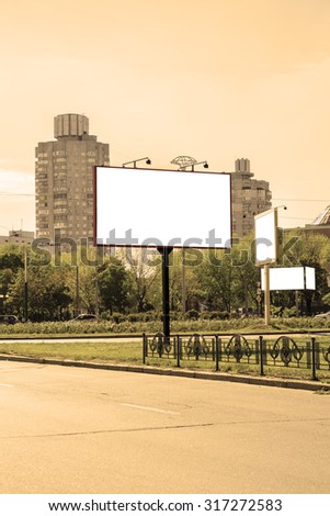 Blank white advertising banners near the road warm filtered. Put your text or images inside
