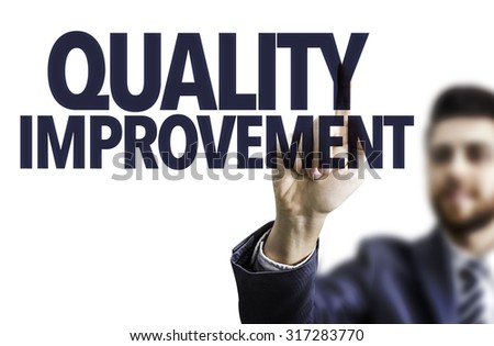 Business man pointing the text: Quality Improvement