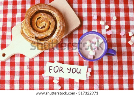 Cup of cocoa with marshmallows and biscuit-curl with raisins. Cutting board. bun, mug of hot chocolate. Kitchen table. Breakfast, Lunch. Food and drink. Surprise. Banner, place for text.
