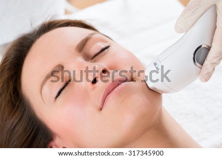 Close-up Of Beautician Giving Laser Epilation Treatment To Young Woman Face Royalty-Free Stock Photo #317345900