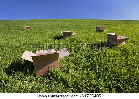 Thinking outside the box concept shot shot on location showing five empty boxes in a green field with a blue sky