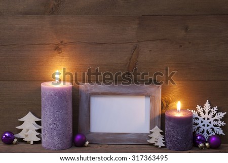 Christmas Decoration With Purple Candles, Christmas Tree, Christmas Ball, Snowflake. Empty Picture Frame For Copy Space. Peaceful Atmosphere With Candlelight. Wooden Background. Vintage Rustic Style