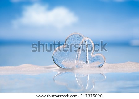 clear glass hearts in foam on wet white glass with reflection