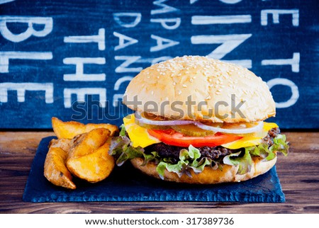 Homemade burger made from fresh vegetables and beef on wooden background