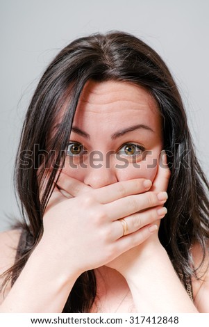 Girl embarrassed and closes the mouth with her hands