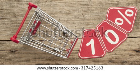 discount 10%, shopping cart on wood background