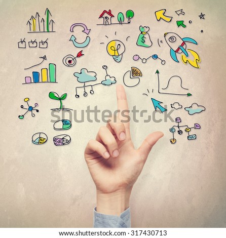 Hand pointing at business idea concepts on light brown wall background