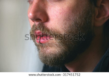 Close up of a man's face with a piercing