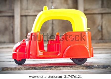 a motor  tricycle toy on wooden background