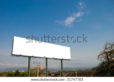 Big white blank billboard with blue sky and mountain backdrop