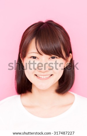 Young Asian girl isolated on pink background