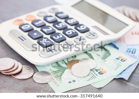 Calculator with money on grey background, stock photo