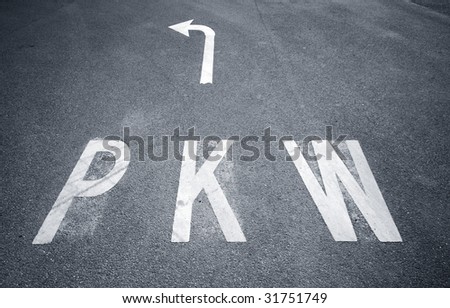 PKW sign and arrow sign on asphalt.