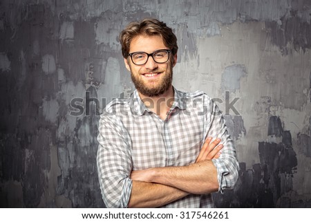 Young handsome man standing with crossed arms