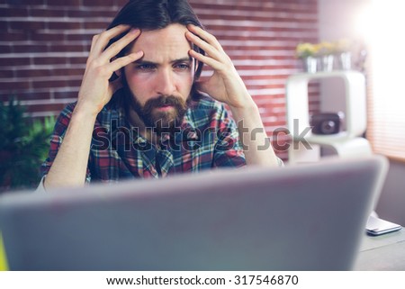 Fraustrated creative businessman looking at laptop in office Royalty-Free Stock Photo #317546870
