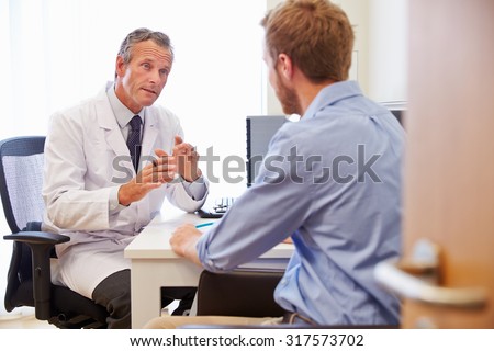 Male Patient Having Consultation With Doctor In Office Royalty-Free Stock Photo #317573702