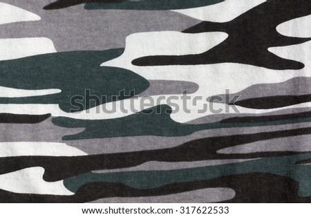 Green gray black white colors of camouflage fabric. The texture of camouflage material. Photographed close-up.