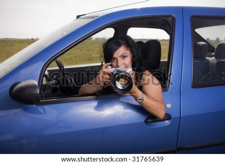 young woman taking photos with telephoto lens - illustrating surveillance