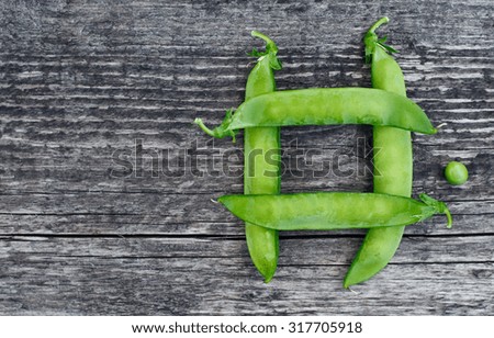 Vintage wooden surface for design with beautifully located pods of green peas
