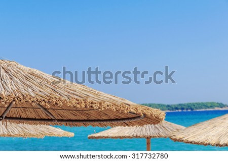 Straw umbrella on beautiful beach background