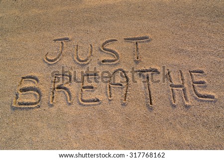 In the picture the words on the sand "Just breathe".