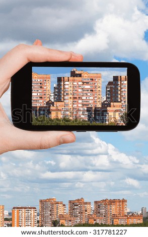 travel concept - tourist photographs picture of residential district on smartphone