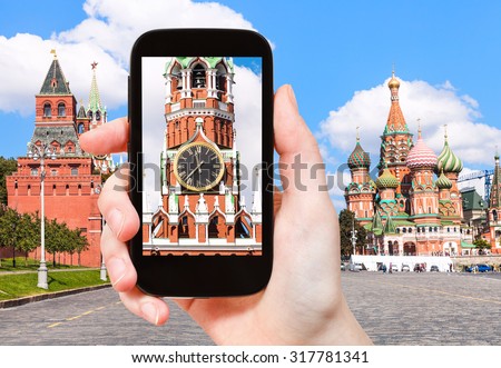 travel concept - tourist photographs picture of Spasskaya Tower and Red Square of Moscow Kremlin on smartphone