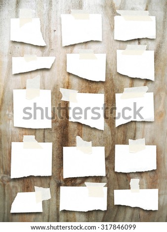 Digital background: multiple pieces of paper with scotch tape-black brown ochre grey white-grungy wooden board background