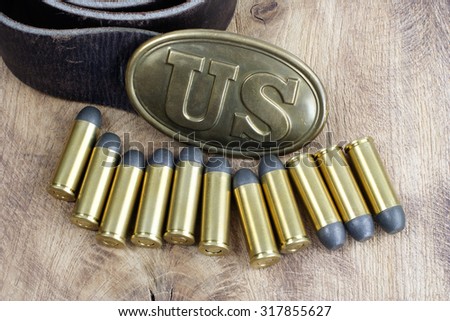 US Belt Buckle Civil War period with revolver cartridges on wooden background