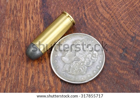 The .45 Revolver cartridges and Silver Dollar Wild West period on wooden background
