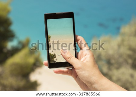 Taking a snapshot of a beautiful beach with a cellphone. 