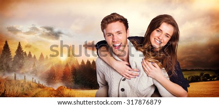 Smiling young man carrying woman against country scene