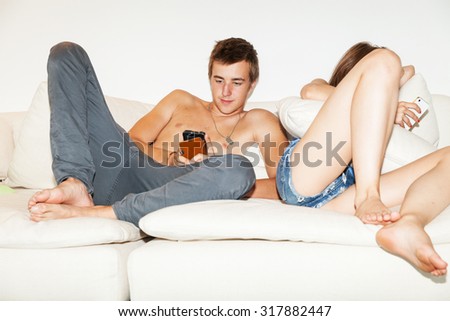 Young bored couple on the couch, chatting alone
