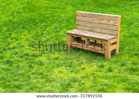 a sense of a small bench in green grass lawn on a day.