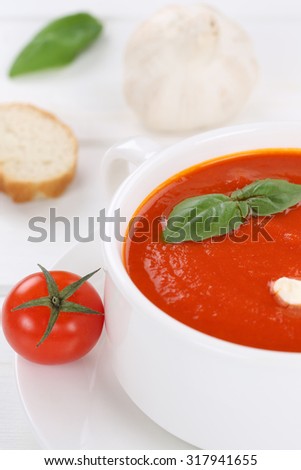 Tomato soup meal with fresh tomatoes and baguette in bowl