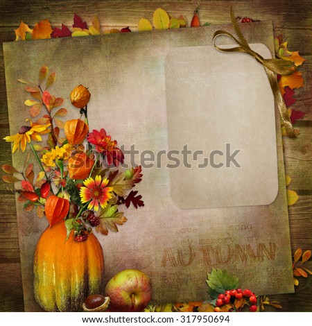 Vintage background with card, a bouquet of autumn leaves and berries in a vase from pumpkin 