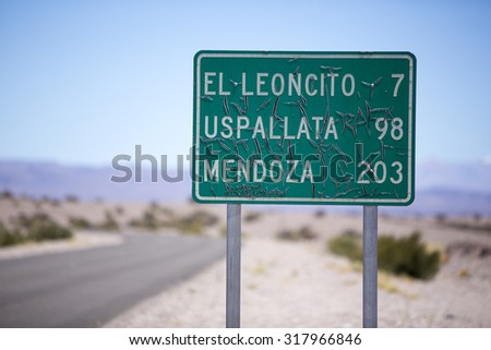 Old distance sign road on paved road with blue sky on the famous Ruta 40 (Route 40). Direction to Mendoza, Uspallata and El Leoncito. San Juan Province Argentina
