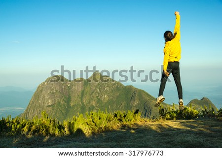 Man Jumping Celebrating Success with the view of a Mountain (Pico Parana - Brazil)
