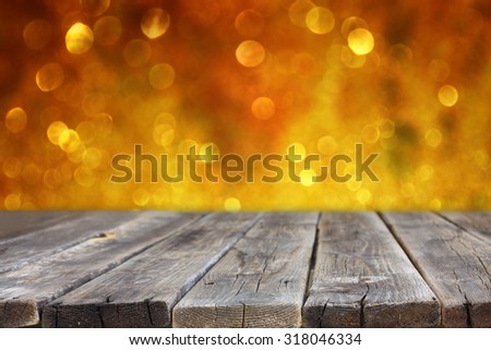 rustic wood table in front of glitter silver and gold bright bokeh lights
