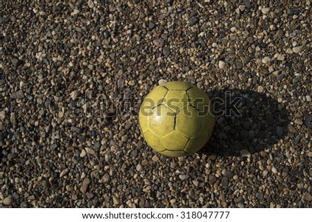 old yellow football on rocks background