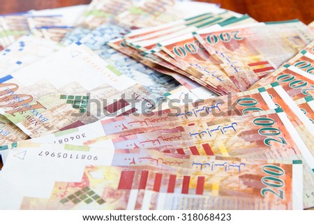 Two hundred and one hundred shekel bank notes against wood background. Concept photo of money, banking ,currency and foreign exchange rates.
