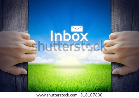 Communication Concept "Inbox". Hands opening a wooden door then found a texts floating among new world as green grass field, Blue sky and the Sunrise.