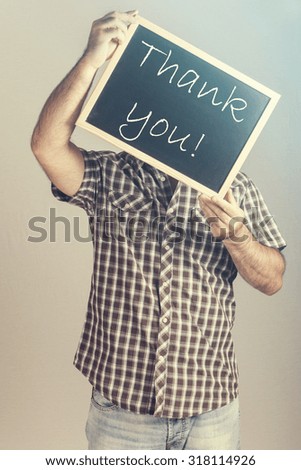 Man holding a Thank You message board. Cross processed image for vintage look