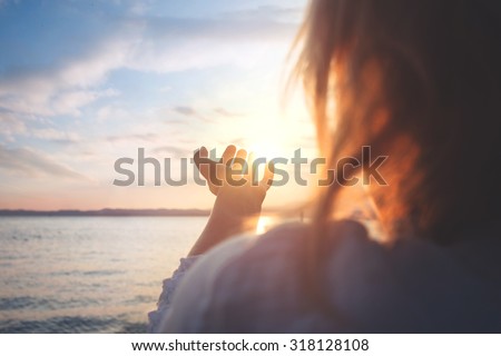 woman try to grab the sun Royalty-Free Stock Photo #318128108
