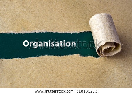 Torn brown paper on green surface with "Organisation" word.