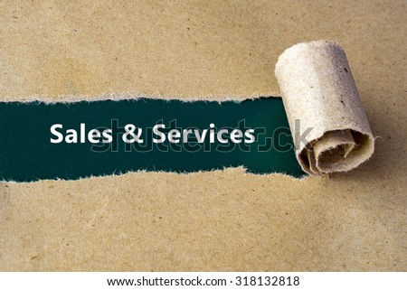Torn brown paper on green surface with "Sales & Services" word.