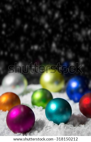 Festive colorful christmas decoration on a snowy background, lot of christmasballs in red, blue, pink, lilac, white, yellow and orange