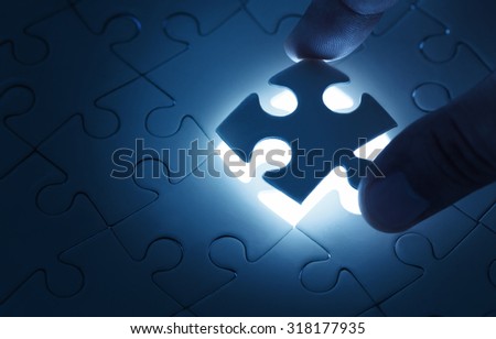 Business concept, male hand putting missing piece of jigsaw puzzle with copy space