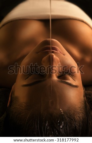 The girl has Shirodhara treatment - indian oil massage. Royalty-Free Stock Photo #318177992