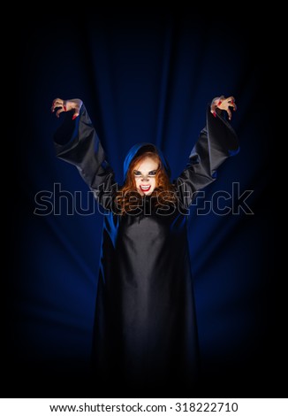 Young witch girl on blue rays of light background